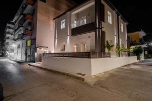 un bâtiment situé sur le côté d'une rue la nuit dans l'établissement Santa Rosa Apartments, à Kalamata