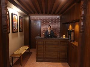 Un uomo seduto al bar in una stanza di Harsha Boutique Hotel a Kathmandu
