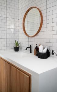Un baño blanco con lavabo y espejo. en Villa Azula Bali, en Canggu