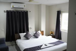 1 dormitorio con 2 camas y cortinas negras en Dwaraka Heaven Luxury rooms, en Kondapur