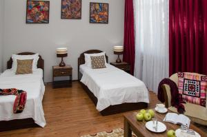 a bedroom with two beds and a table with fruit on it at Hotel Jipek Joli in Nukus +30 photos