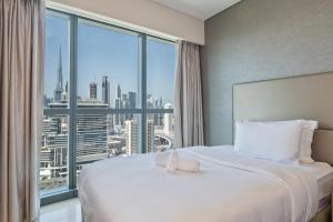 a hotel room with a large bed and a large window at 2BR Luxurious Damac Paramount Burj Khalifa view Pool, Gym, Bar & Sauna in Dubai +47 photos