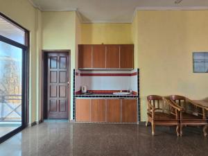 a kitchen with wooden cabinets and a table at Hotel O Villa Impiana in Bachok