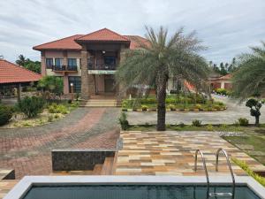 a house with a swimming pool and a palm tree at Hotel O Villa Impiana in Bachok