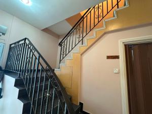 a staircase with black railings in a house at Hotel O Rainfield Inn in Kota Kinabalu