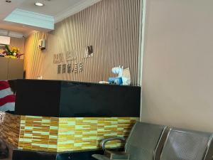 a waiting room with a chair and a wall at Hotel O Rainfield Inn in Kota Kinabalu