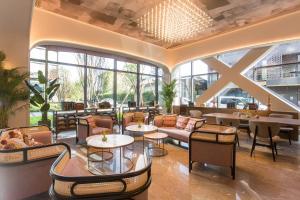 a lobby of a hotel with tables and chairs at Mercure Xichang in Xichang