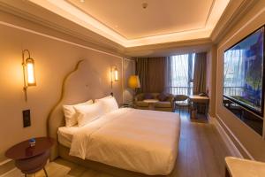 a hotel room with a bed and a flat screen tv at Mercure Xichang in Xichang
