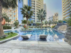 a swimming pool with two chairs in a resort at 2BR Luxurious Damac Paramount Burj Khalifa view Pool, Gym, Bar & Sauna in Dubai