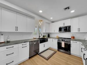 a kitchen with white cabinets and stainless steel appliances at Boulder Apache Junction in Apache Junction