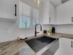 a kitchen with white cabinets and a sink at Boulder Apache Junction in Apache Junction