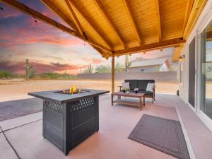 an outdoor patio with a fireplace and a table at Boulder Apache Junction in Apache Junction