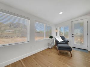 a living room with a chair and two windows at Boulder Apache Junction in Apache Junction