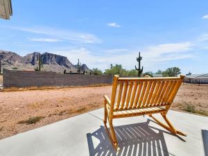 a wooden bench sitting on a sidewalk next to a field at Boulder Apache Junction in Apache Junction
