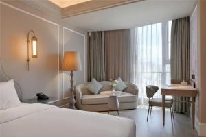 a hotel room with a bed and a chair and a table at Mercure Xichang in Xichang +29 photos