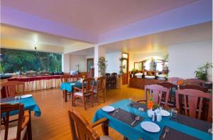 a restaurant with blue tables and chairs and a cafeteria at Lazo Golden Valley Resort , Munnar in Munnar