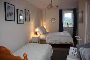 1 dormitorio con 2 camas y ventana en Chambres d'Hôtes La Roumec, en Escandolières