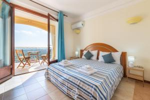 a bedroom with a bed and a balcony with a view at Estay - Ginestre 13 - Dreaming view in Is Molas 