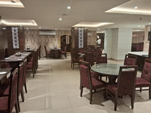 a dining room with tables and chairs in a restaurant at Hotel Royal Serena in Ambāla