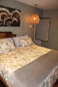 Un dormitorio con una cama grande y una lámpara. en Matumi Trail Forest Lodges - Matumi and Mitzeeri, en Tzaneen