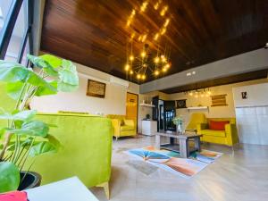 a living room with a yellow couch and a table at Executive Suites and Spa in Letlhakawe