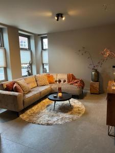 a living room with a couch and a table at 't Voorhuys Noordwijk aan Zee- tuin en gratis parkeren in Noordwijk