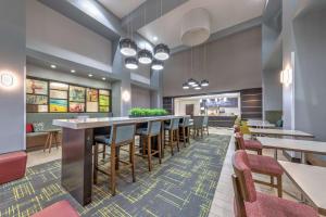 Clute杰克逊湖-克鲁特汉普顿套房酒店的餐厅设有长长的酒吧,配有桌椅