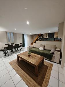 a living room with a green couch and a table at Jolie Maison au 34 centre-ville in Angoulême
