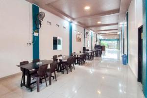a row of tables and chairs in a restaurant at RedDoorz Syariah at Wisma Seroja Indah Duri in Duri
