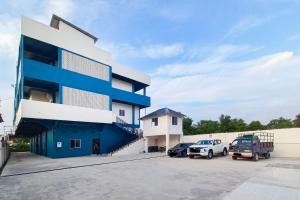 a building with cars parked in a parking lot at RedDoorz Syariah at Wisma Seroja Indah Duri in Duri
