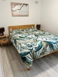 Un dormitorio con una cama con un edredón colorido. en Caves Beach Holiday House, en Caves Beach
