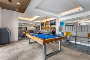 une table de billard dans une pièce avec des canapés dans l'établissement Homewood Suites By Hilton Colorado Springs Airport, à Colorado Springs