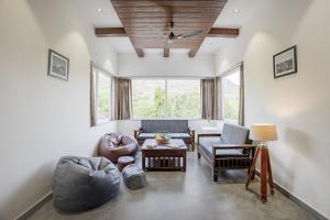 NāiにあるAlaya Stays Kasturi Villa - Pet Friendly 6 BHK with Plunge Poolのソファと椅子とテーブルのあるリビングルーム