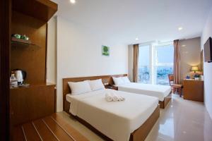 Postel nebo postele na pokoji v ubytování Golden Light Da Nang Hotel