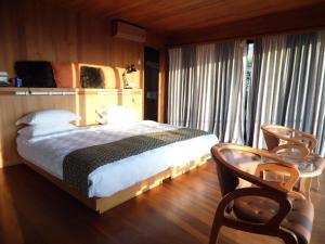 a bedroom with a bed and a desk and a chair at Aythaya Monte diVino Lodge in Taunggyi