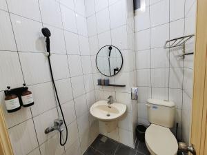 uma casa de banho com um WC, um espelho e um lavatório. em 幸運草輕旅 em Jiaoxi