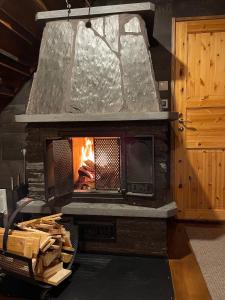a stone fireplace in a room next to a door at Riverside cabin Hiekkaranta in Kuusamo +64 photos