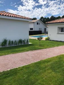 Maison de vacances Moliets et maa في موليات-إي-ما: منزل وساحة مع ساحة عشبية