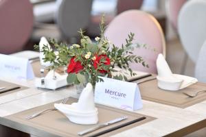 a table with a vase with flowers on it at Mercure Xichang in Xichang