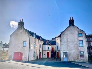 an old building with two chimneys on a street at 3 The Granary in Banff