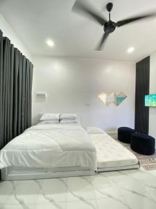 a bedroom with a bed and a ceiling fan at D'Lamp Studio in Kampung Kuala Besut