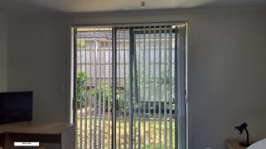 una puerta corredera de cristal con vistas a un patio en 19 Arahi Place, Rototuna North -Hamilton NZ, en Hamilton