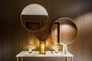 a bathroom with a mirror and a shelf with a clock at Elements Hotel&Spa in Świeradów-Zdrój