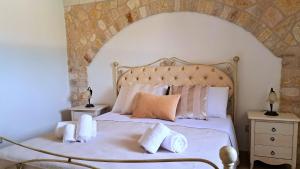 a bedroom with a large bed with white sheets and pillows at Fogliantica Azienda Agrituristica in Ceglie Messapica +74 photos