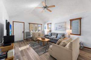 a living room with a couch and a ceiling fan at Barge Road Beach House in Ocean City