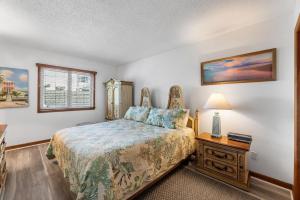 a bedroom with a bed and a table with a lamp at Barge Road Beach House in Ocean City