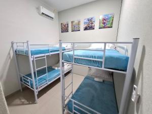 two bunk beds in a room with paintings on the wall at Koala Tidur Hostel Syariah Yogyakarta in Seturan