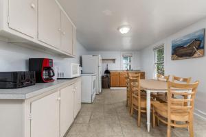 a kitchen with white cabinets and a table and chairs at Somerset 4 in Ocean City