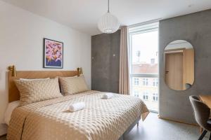 a bedroom with a bed and a large window at Nørrebrogade 209 in Copenhagen