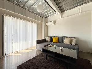 ein Wohnzimmer mit einer Couch und einem Couchtisch in der Unterkunft b hotel Komachi 1 BR Apartment Free Breakfast Included in Hiroshima